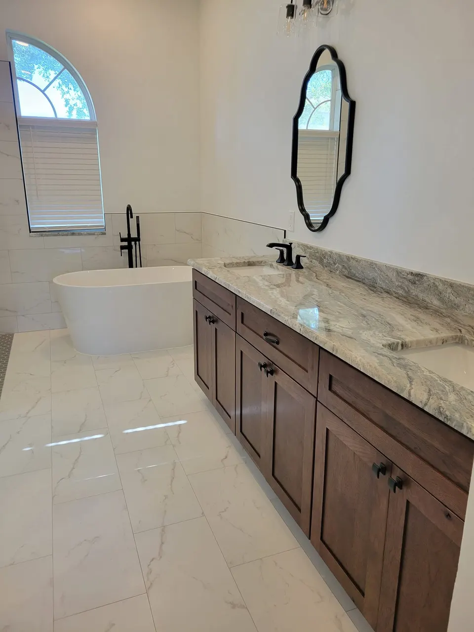 Finished bathroom remodel with tile, vanity, and freestanding tub